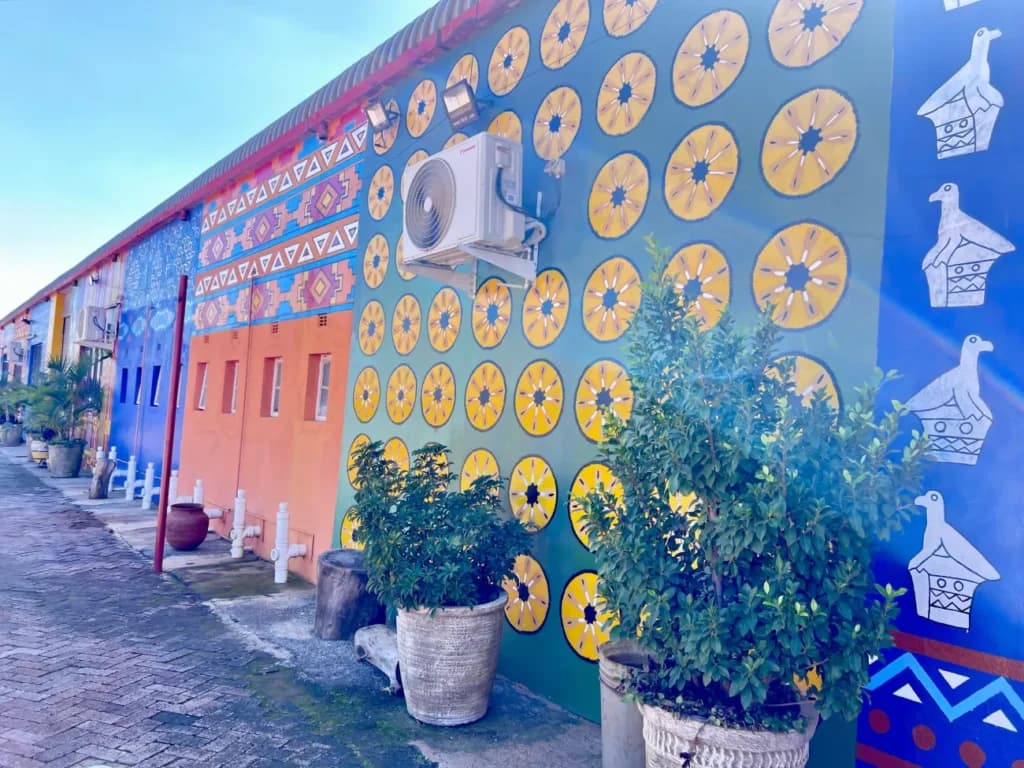 Sun motifs and Zimbabwe bird panels on a blue wall