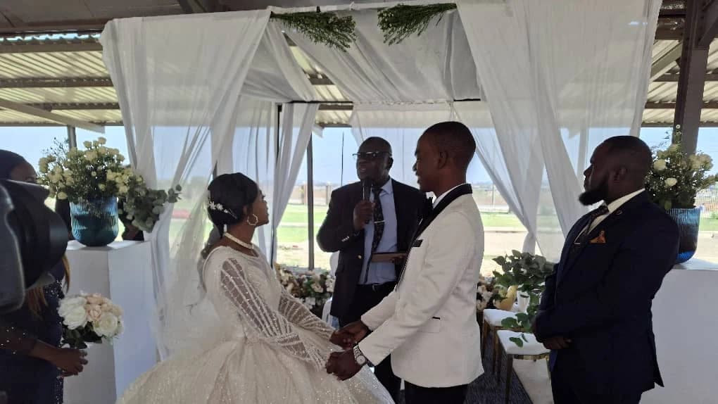 A wedding ceremony under the draped pavilion